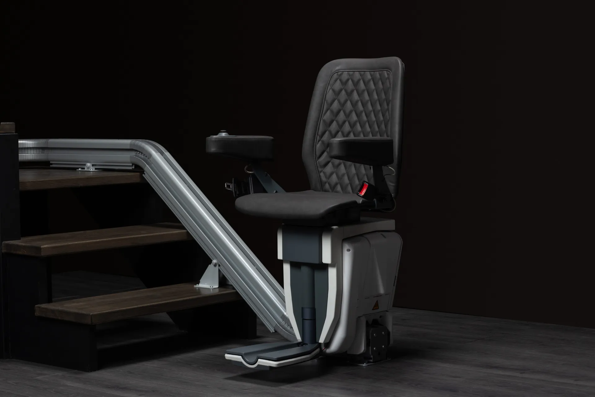 Monte-escalier Upstairlift Black — vue de profil au bas de l'escalier avec repose-pieds déployé